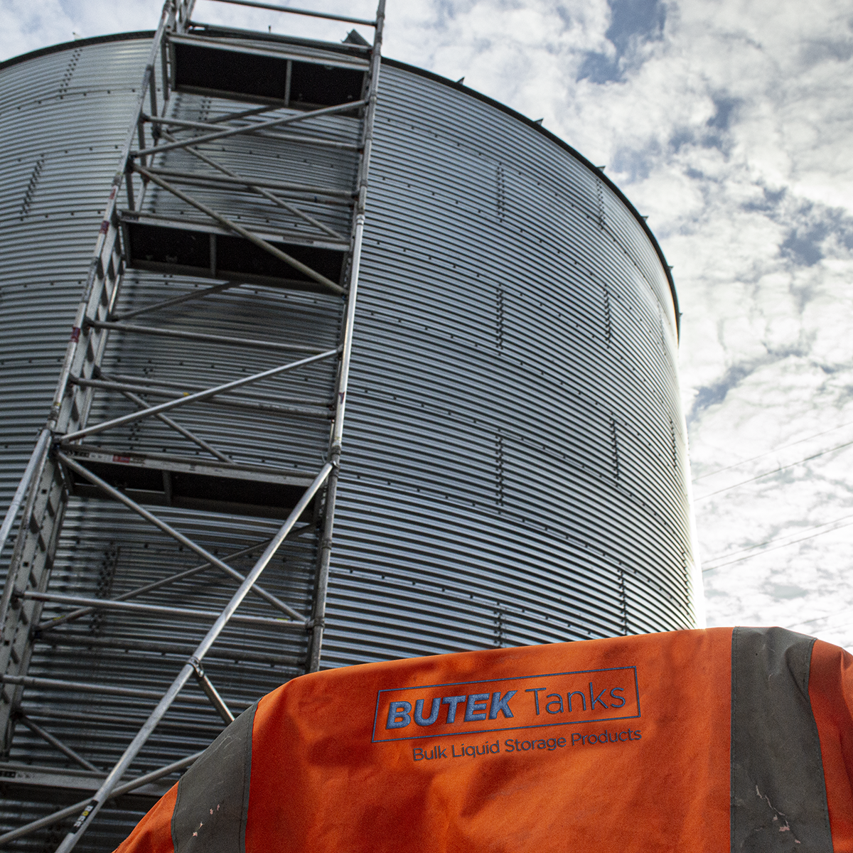 Demountable steel water tank with an orange hi vis depicting butek tanks logo